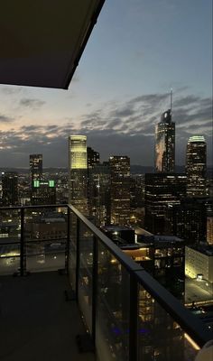 the city skyline is lit up at night, with skyscrapers in the foreground