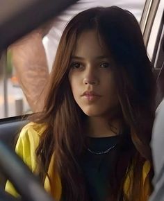 a woman sitting in the back seat of a car with her hand on her hip