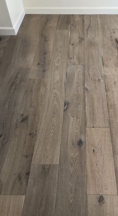 a wood floor is shown with white trim and gray stain on the top half of it