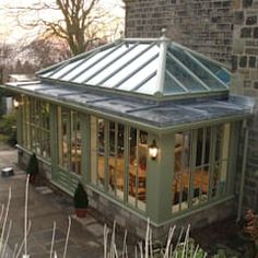 a house with a green roof and glass windows