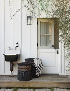 two baskets sitting on the porch next to a sink