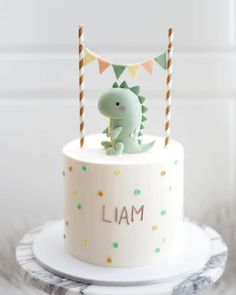 a small cake with a dinosaur on top and the word i am spelled in white frosting