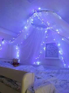 a bed with white sheets and lights on it