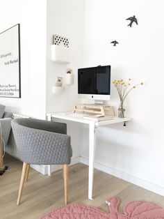 there is a desk with a computer on it and two chairs in front of it