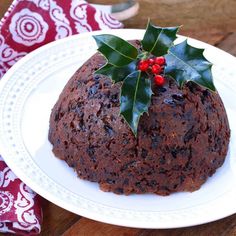 a christmas pudding on a white plate with holly