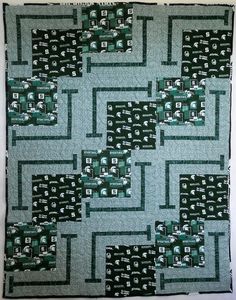 a green and black quilt with squares on it