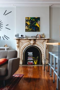 a living room filled with furniture and a fire place next to a wall mounted clock