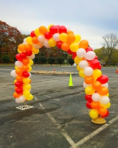 an arch made out of balloons in a parking lot