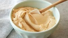 a white bowl filled with peanut butter and a wooden spoon