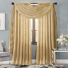 a living room with a couch, chair and window covered in gold drapes