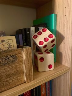 two wooden dices stacked on top of each other in front of bookshelves