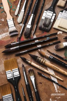 many different paint brushes are on the table