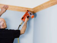 a man is using a drill to fix the ceiling