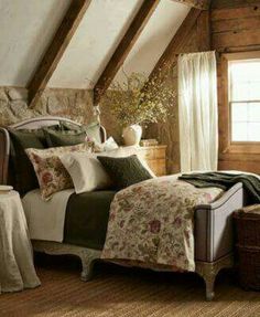 a bed in a bedroom with pillows and blankets