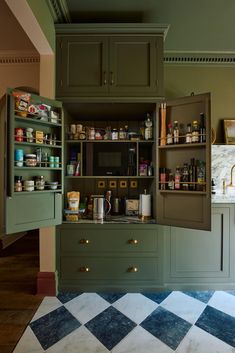 a kitchen with green cabinets and white checkered flooring on the floor is shown