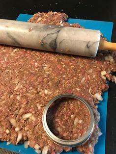 a rolling pin is sitting on top of the ground beef and onions that are ready to be cooked