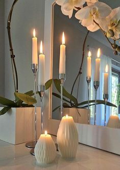 candles are lit in front of a mirror