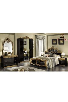 a bedroom with a bed, dresser and mirror in the middle of it's room