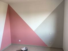 an empty room with pink and grey walls