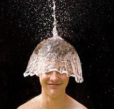 a woman under a shower head covered in water