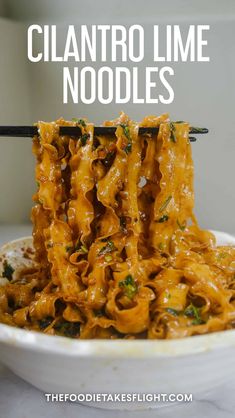 a white bowl filled with noodles and sauce on top of a marble counter next to a black chopstick