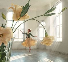 a woman standing in front of a vase filled with flowers