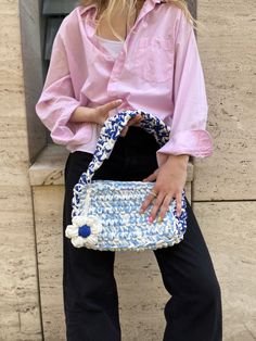 a woman holding a blue and white purse