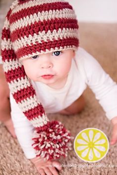 a baby wearing a red and white striped hat