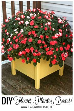 a yellow planter with red and white flowers in it sitting on a wooden deck