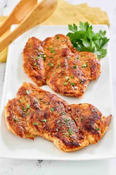 two chicken patties on a white plate with parsley