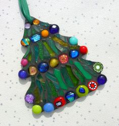 a glass christmas tree ornament hanging on a wall