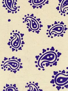 blue and white paisley designs on a cream colored background, with small dots in the center