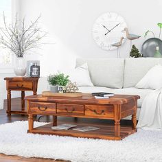 a living room with a couch, coffee table and clock on the wall above it