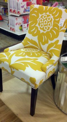 a yellow and white chair sitting on top of a wooden floor next to a store shelf