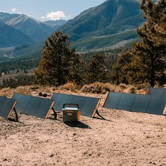 there are many empty chairs on the ground in the mountains near some trees and bushes