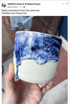 someone is holding up a cup with blue paint on it