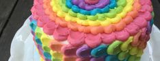 a multicolored cake is sitting on a plate