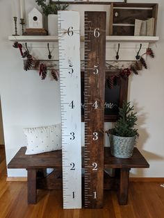 a tall wooden ruler sitting on top of a table next to a potted plant