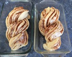 two glass dishes filled with cinnamon rolls on top of a counter next to each other