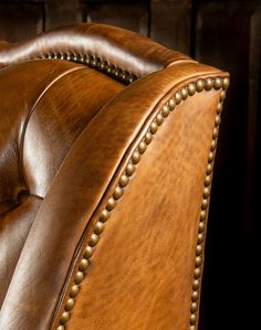 a brown leather chair with studding on it