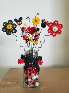 a vase filled with lots of different types of buttons and flowers on top of a table