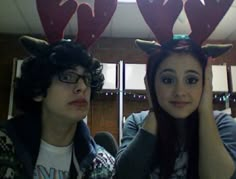 two people wearing reindeer antlers on their heads