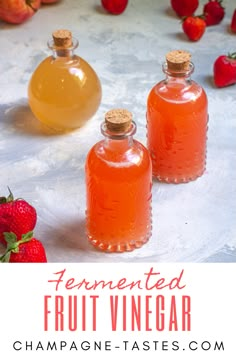 two bottles of homemade fruit vinegar next to strawberries on a table with text overlay that reads fermented fruit vinegar