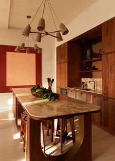 a large kitchen island in the middle of a room with wooden cabinets and counter tops