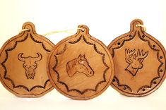 three wooden ornaments with deer heads on them