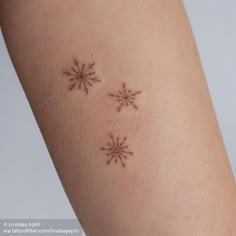 two small snowflakes on the back of a woman's arm