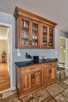 a kitchen with wooden cabinets and black granite counter tops in the middle of the room