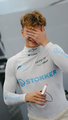 a man covering his eyes while standing next to a boat