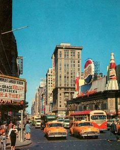 an old photo of cars and people on the street in front of some tall buildings