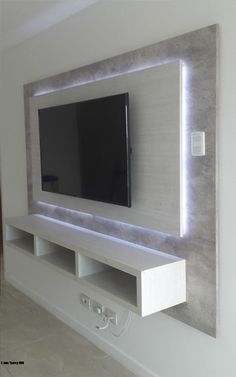 a flat screen tv mounted to the side of a wall in a room with white walls